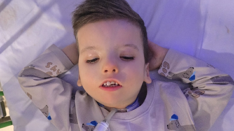 Teddy resting peacefully, arms behind his head, wearing pyjamas.